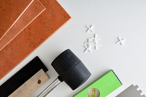 Tiles and tools for laying them on a white table, an Architecture Photo by Davizro's Market