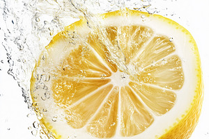 Fresh lemon slice splashing into, a Food & Drink Photo by MistyDay