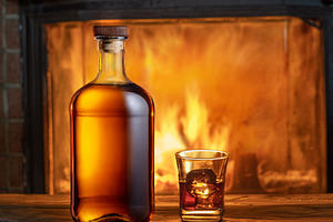 Glass of whiskey and whiskey bottle on old wooden table and blur, a Food & Drink Photo by Volff