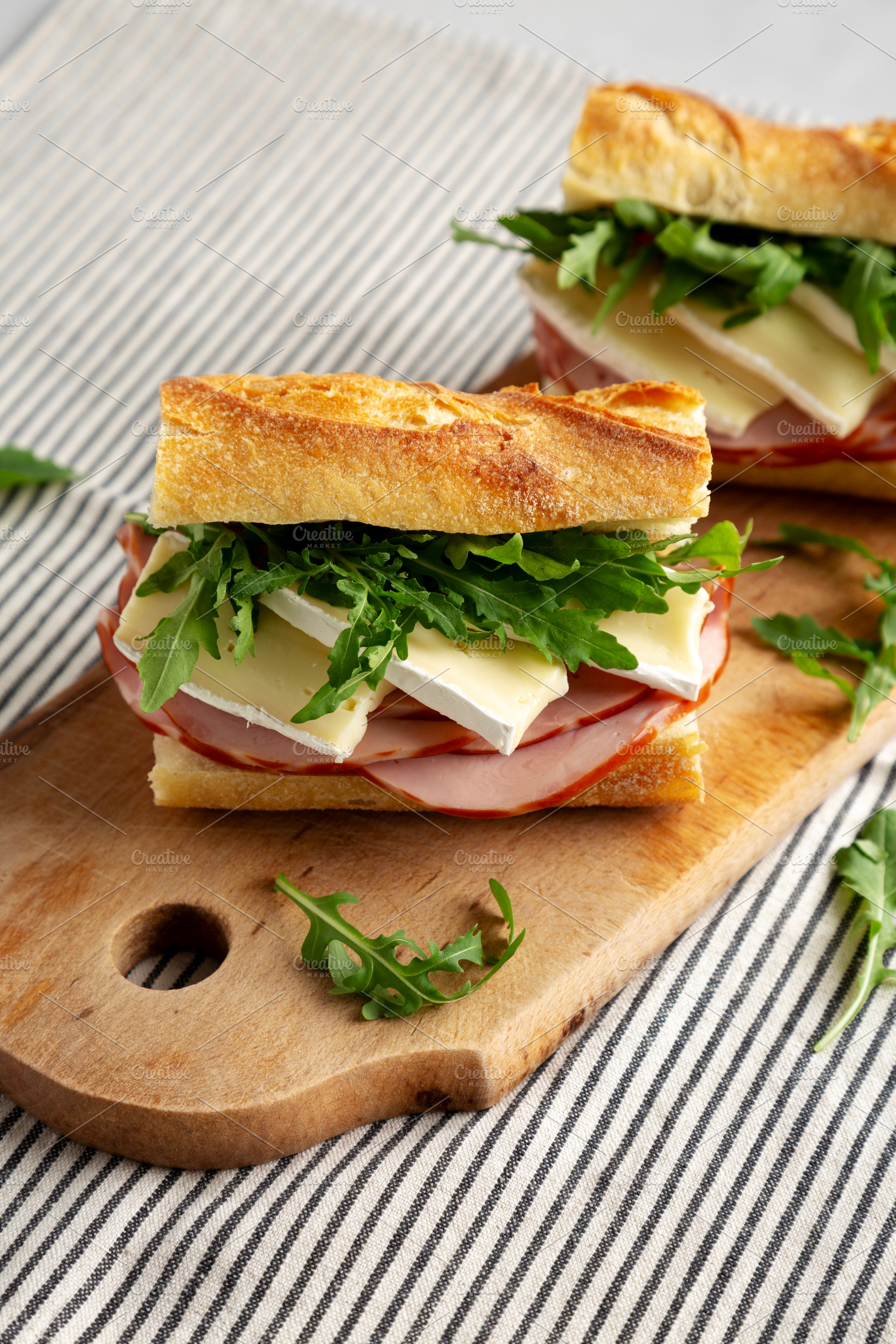 Homemade French Ham and Brie Baguette with Arugula Greens, side, a Food & Drink Photo by LiudmylaChuhunova