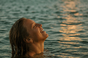 Joyful woman enjoying a sunset swim, a Beauty & Fashion Photo by Virgo Studio