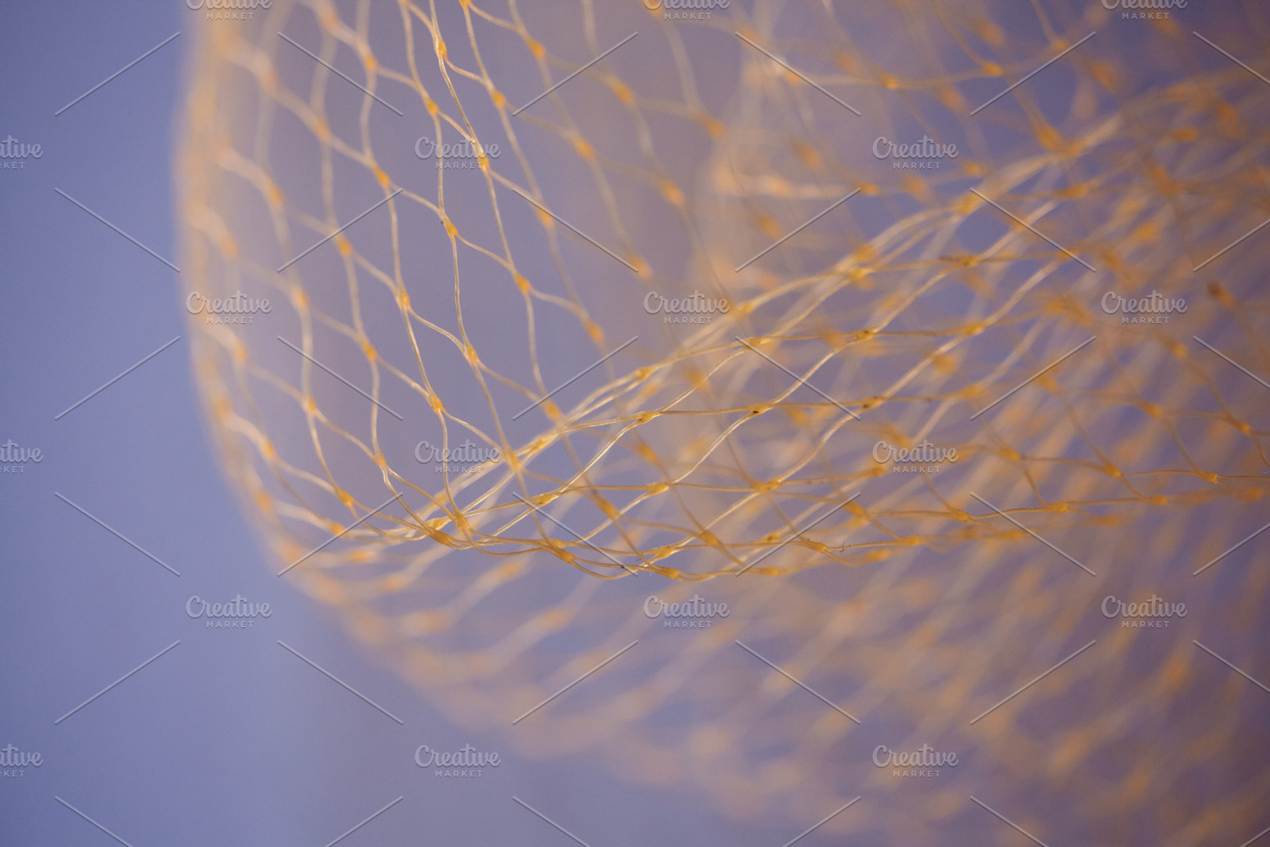 Abstract macro of a golden nylon net against a soft purple background. Flowing, an Abstract Photo by Rohan Photography