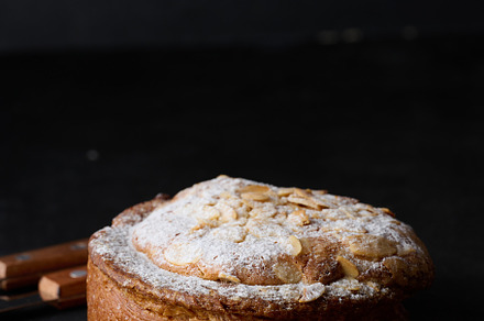 Round pastry with almonds and butter sprinkled with powdered sug, a Food & Drink Photo by ndanko