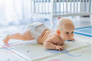 Baby lying on play mat learning to, a Person Photo by Elizaveta Galitskaya