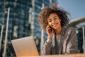 Happy businesswoman working outdoors, a Photo by Pixeness Studio