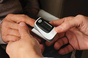 a doctor assessing an elderly woman with oximeter, a Photo by Nito