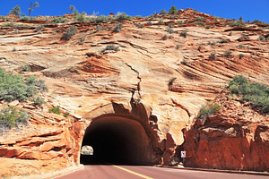 The road passes through a tunnel in, a Nature Photo by kavram