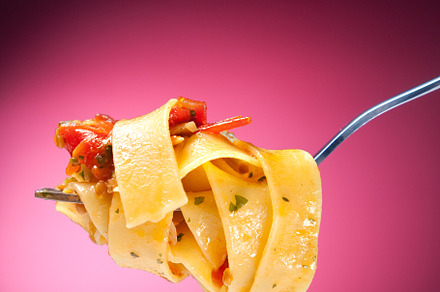 Tagliatelle with clams on a red background
