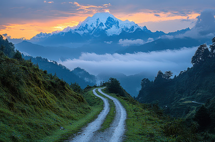 Mountain road leading to snowy peaks, a Background Photo by Pixeness