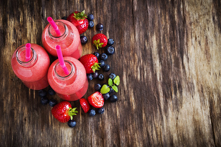 Strawberry smoothie containing smoothie, glass, and strawberry