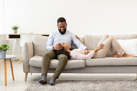 African american couple spending weekend together lying on couch, a Photo by Prostock-Studio