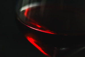 Red wine swirling inside an elegant wine glass against a dark background, showi, a Photo by Studio ANNA