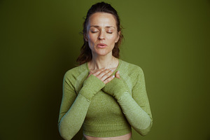 Serene woman in green, eyes closed, a Person Photo by Alliance Images