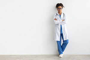 Portrait of black doctor posing with folded arms, a Photo by Prostock-Studio