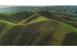 Lush rolling hills covering Sumba, a Nature Photo by Goinyk