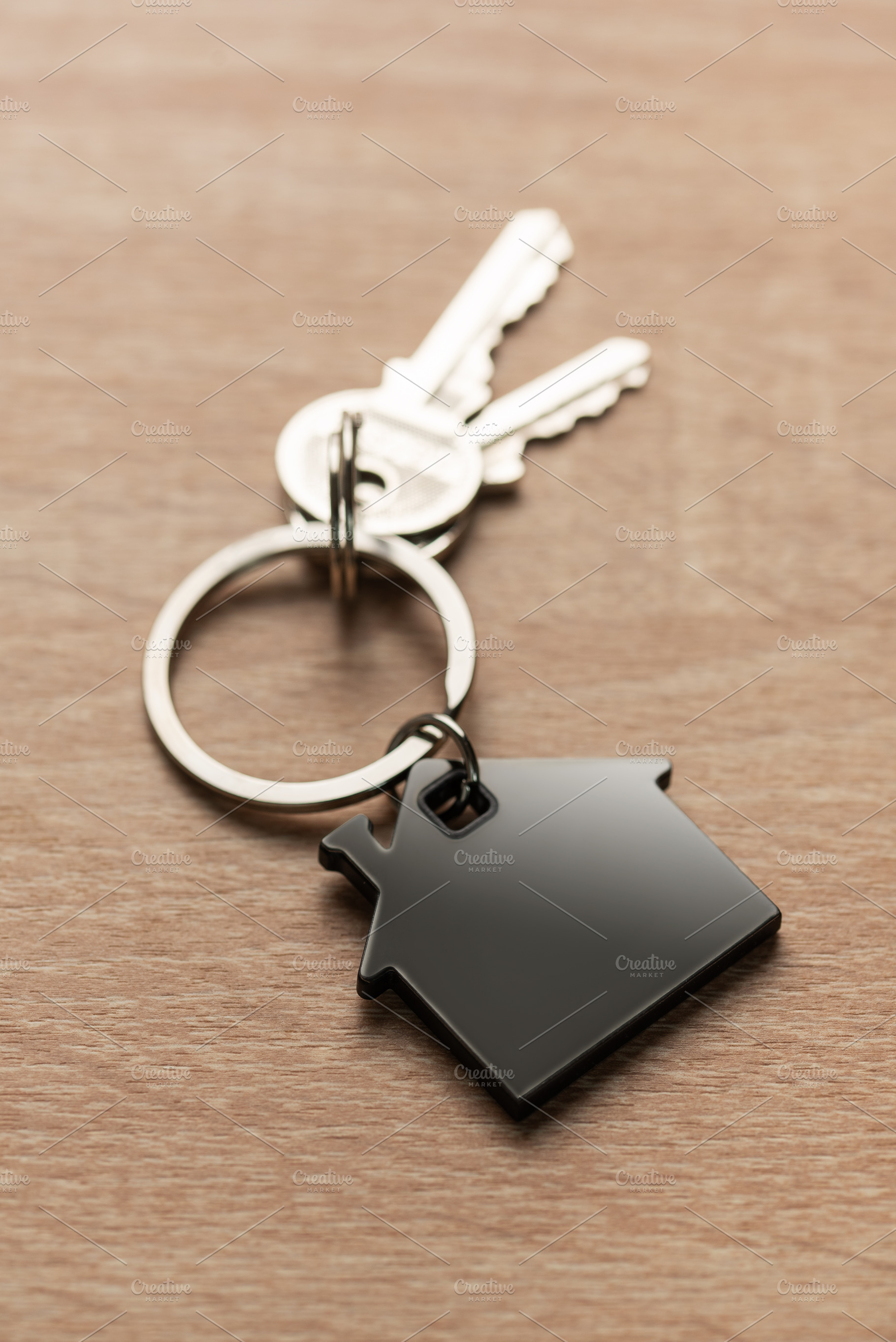House keys with house shaped keychain on wood, a Business Photo by Olena Rudo