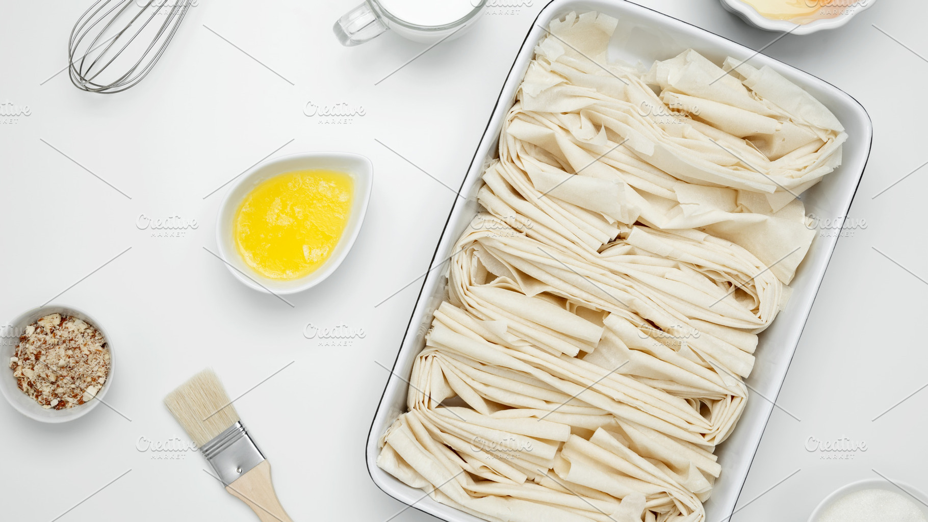 Filo dough in a baking dish next to Crinkle Cake butter for greasing, a Photo by matucha