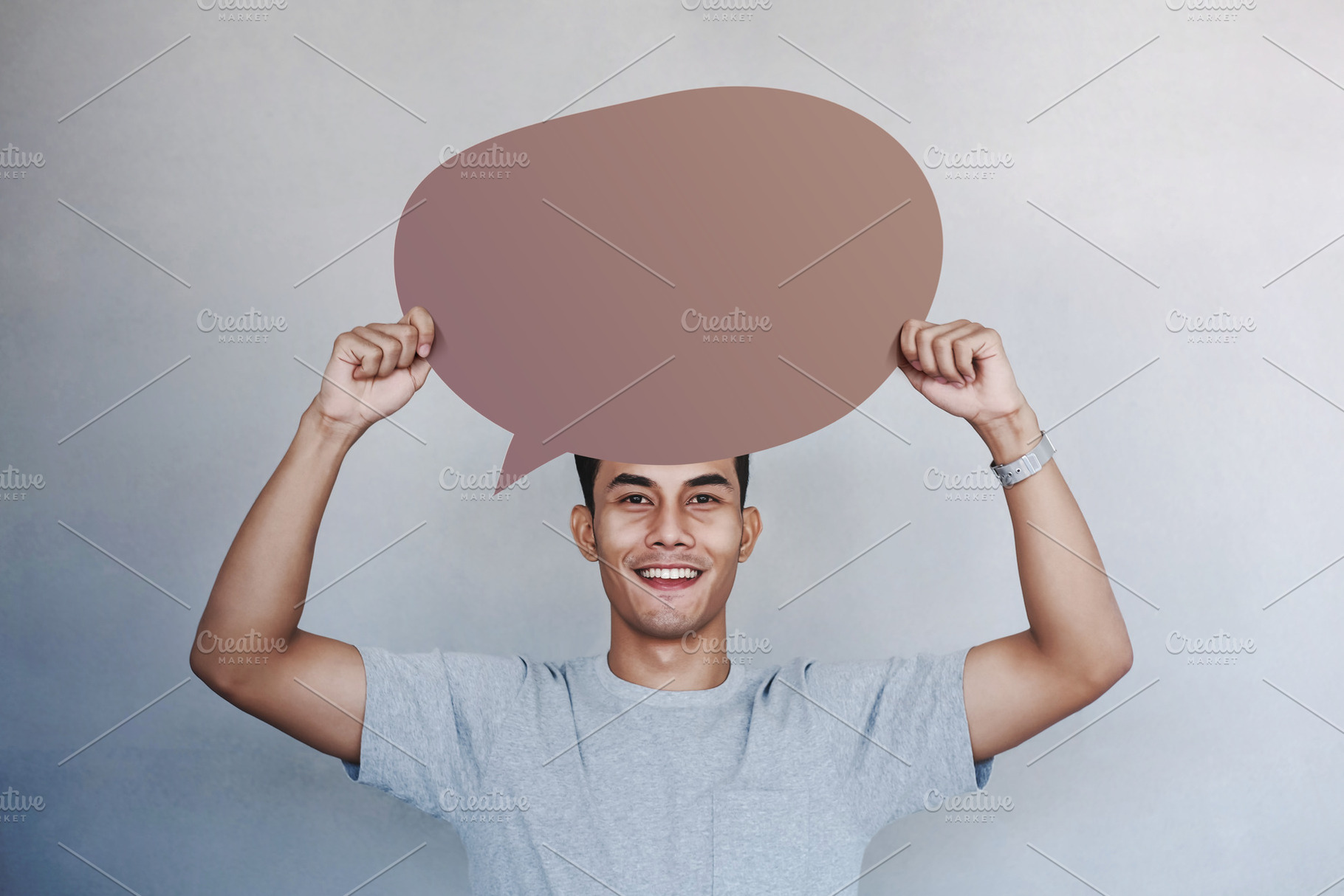 Smiling man holding blank speech bubble in studio. Positive conc, a Photo by salmon.black