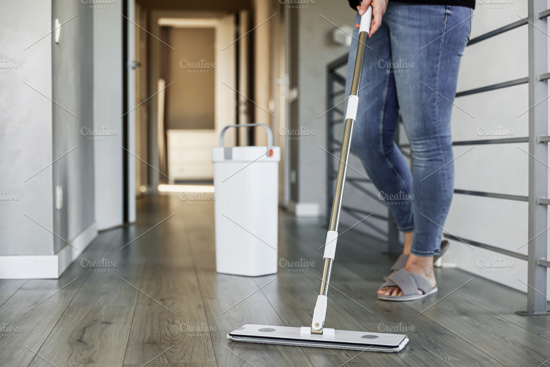Woman mopping, wiping floor in home setting. Housewife uses mop, plastic bucket, a Person Photo by Lenor4ik