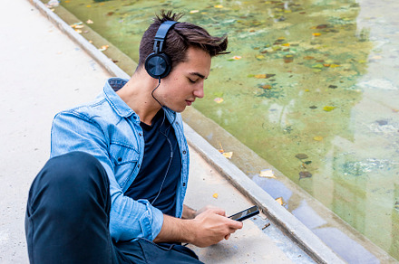 Man listening to music by a pond., a Person Photo by RF Images