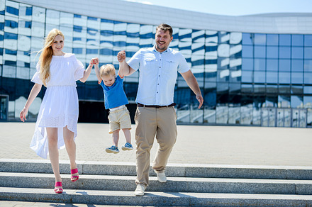 Young family with a baby walking containing family, city, and happy