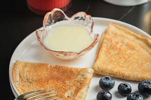 Pancakes with blueberry and honey on a white plate, a Food & Drink Photo by Budarinphoto