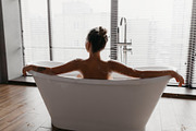 Back view of young lady taking foamy bath, looking out window in modern bathroo, a Photo by Prostock-Studio (Thumbnail 1 of 3)