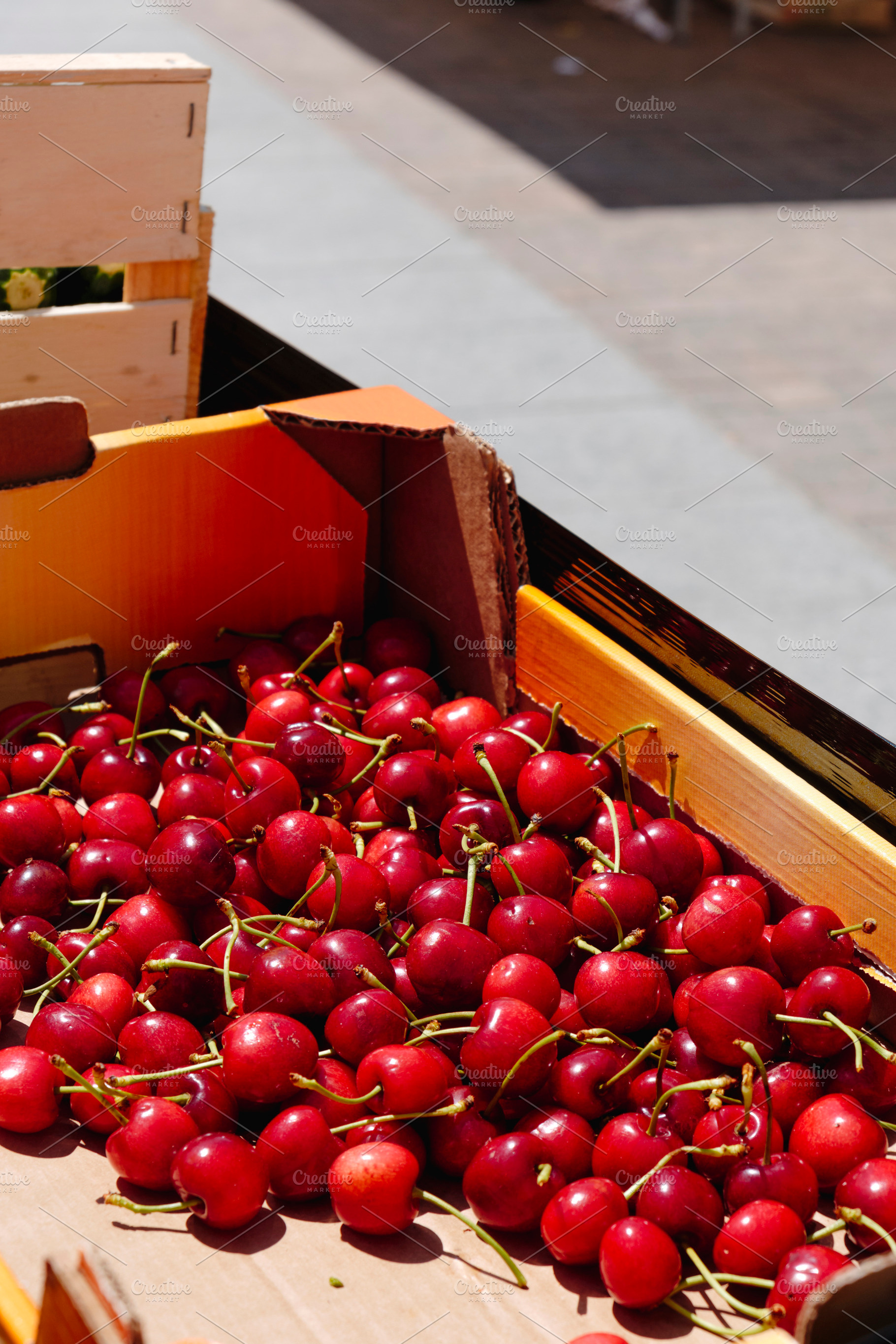 ripe cherries in a cardboard crate, a Photo by Nito