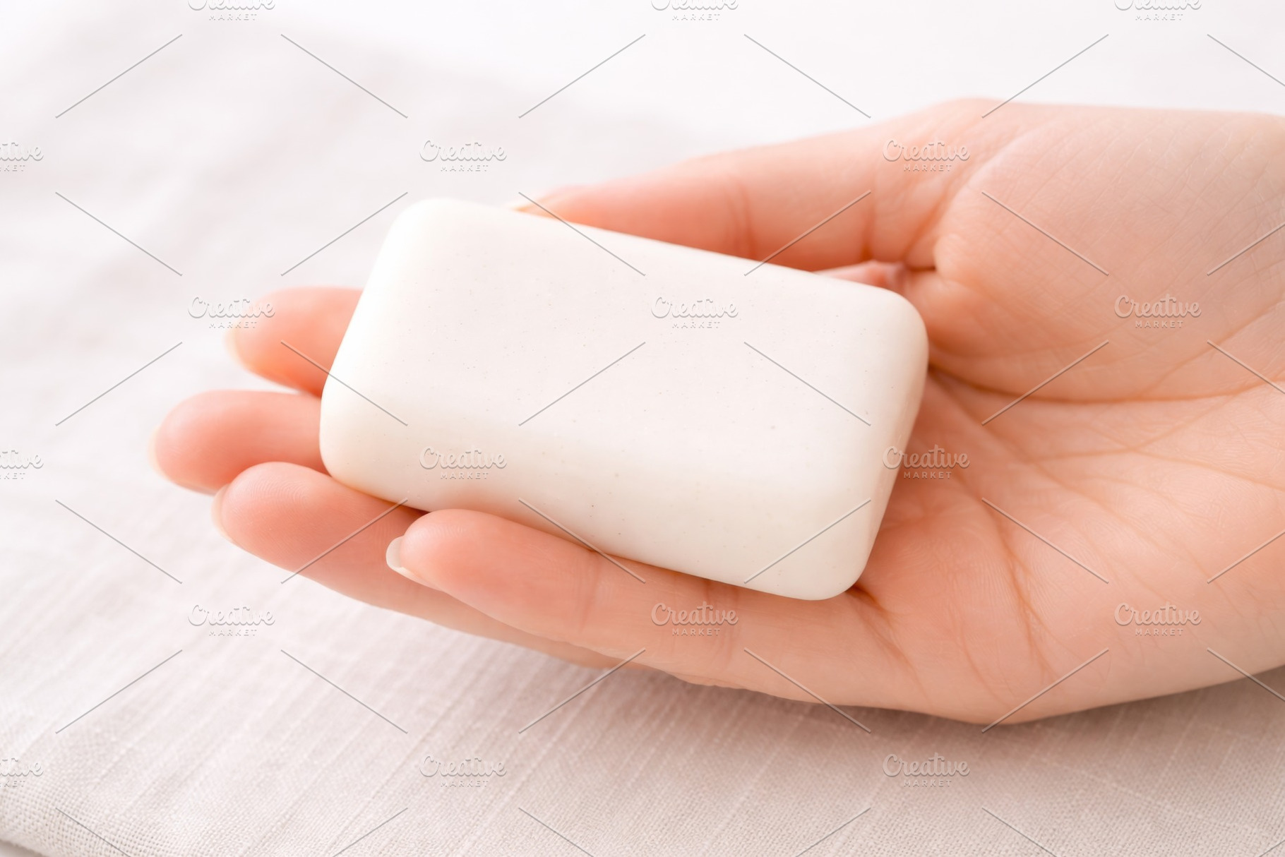Soap bar held in hand on fabric back, a Photo by Dvoevnore photos