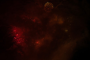 Fireworks exploding behind a wall of smoke