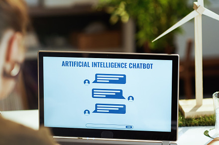 Seen from behind modern business woman with ai chatbot chatting, a Business Photo by Alliance Images