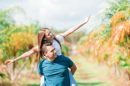 Family of daughter and father having fun among palm trees on vacation. Family v, a Person Photo by travnikovstudio