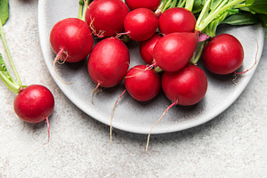 Fresh red radishes with green leaves on plate, a Food & Drink Photo by Olena Rudo