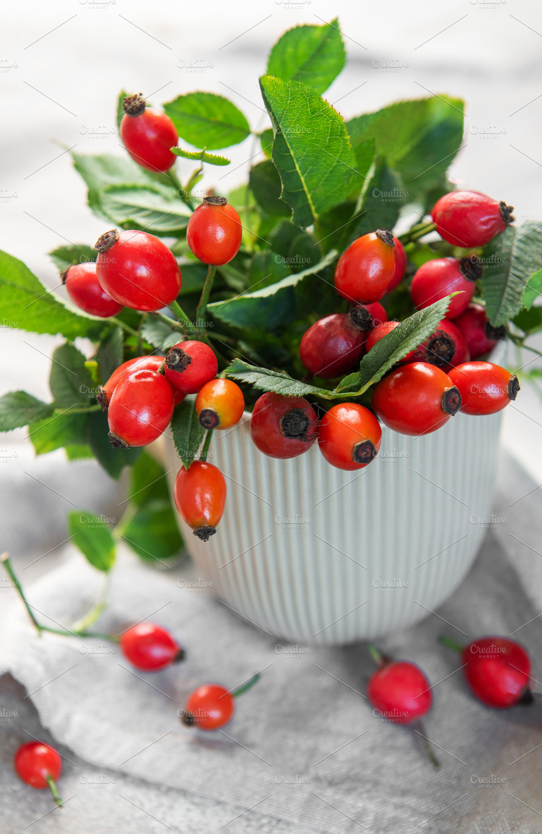 Rose hips spilling from a vase create a vibrant display of autum, a Food & Drink Photo by Olena Rudo
