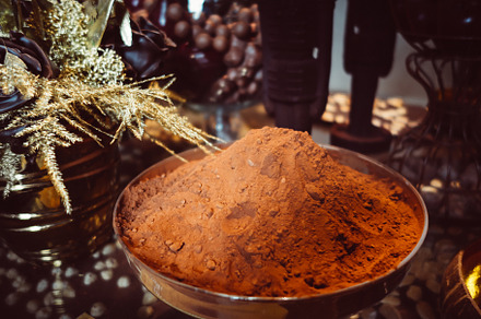 Cocoa powder in a metal cup on a rustic table, a Food & Drink Photo by GoodGoods