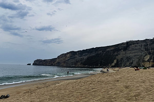 Peaceful coastal view of Nazare Beach under cloudy skies in Portugal, a Photo by AS photostudio
