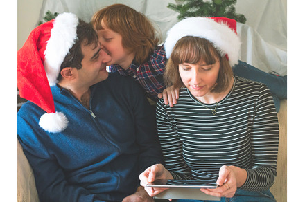 Mother, dad and son in santa caps on, a Holiday Photo by Lifemorning