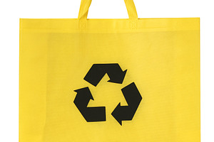 Yellow reusable shopper bag with black recycling symbol in the c, an Abstract Photo by ndanko