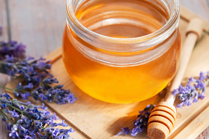Honey jar with lavender flowers on wooden board, a Food & Drink Photo by Olena Rudo