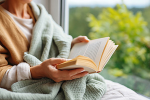 Enjoying a peaceful morning with a hardcover book wrapped in a cozy blanket bes, a Photo by AlyaAnd