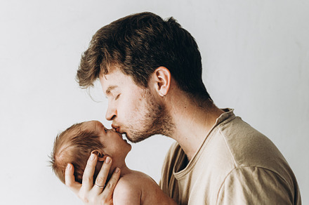 Happy Fathers day!  Stylish father kissing and hugging cute litt