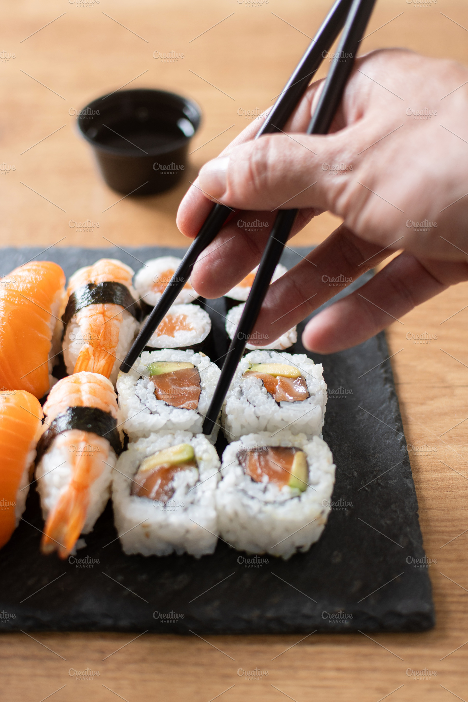 Woman eating sushi with chopsticks, a Food & Drink Photo by etorres69