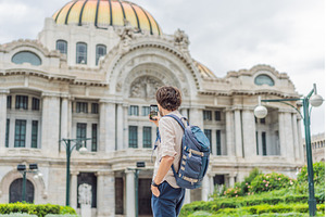 Male tourist standing in front of, an Architecture Photo by Elizaveta Galitskaya