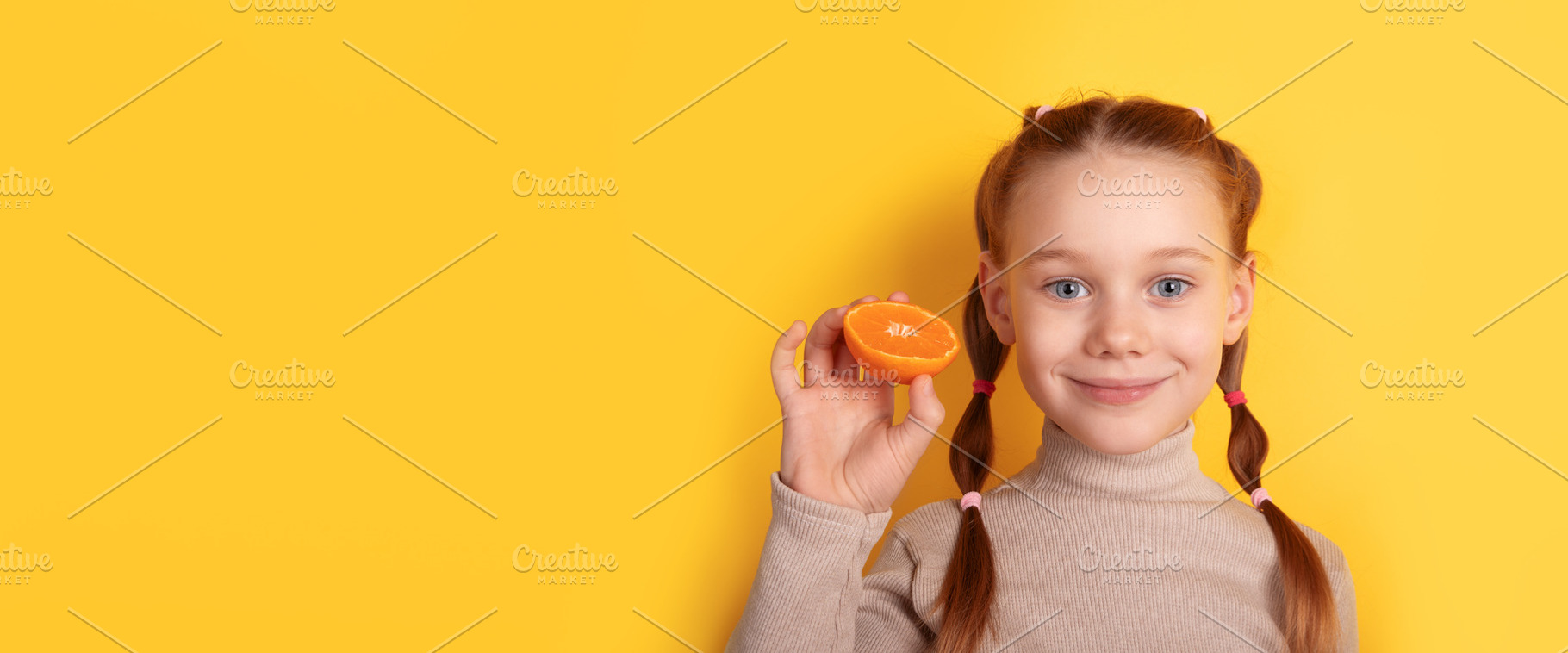 Cheerful young girl holding an orange slice against a vibrant ye, a Photo by Ales Munt