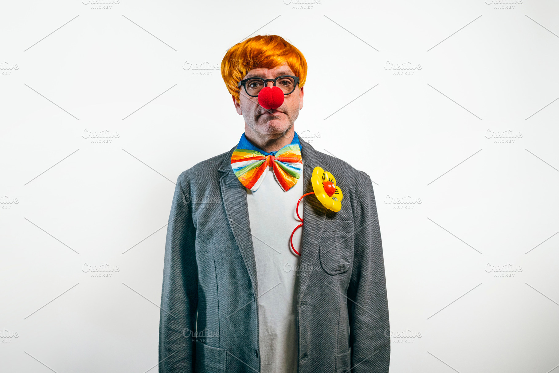 Clown in suit wearing red nose and bowtie, a Person Photo by karrastock