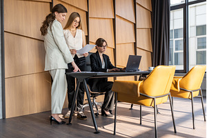 Three businesswomen are actively, a Business Photo by undrey