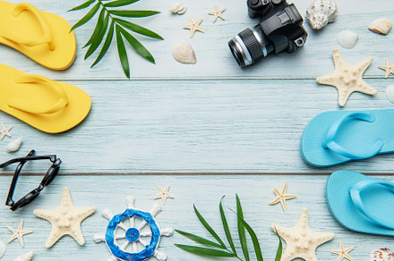 Summer accessories arranged on blue wooden planks create the per