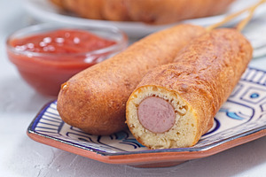 Corn dogs on white blue plate, served with ketchup, horizontal closeup, a Food & Drink Photo by iuliia_n