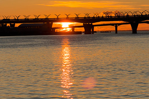 A serene sunset over a calm body of water, with a bridge silhouetted against th, a Nature Photo by Textures & Backgrounds
