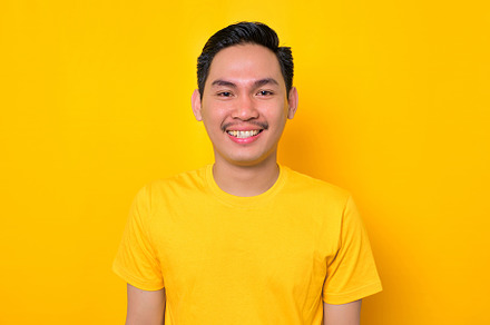 Smiling Asian man looking at camera, a Person Photo by Sewupari Studio